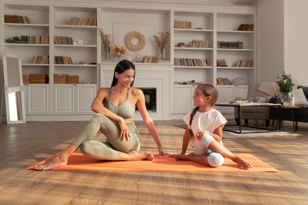 Foto gratuita donna e bambino a tutto campo sul tappetino da yoga