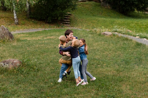 Full shot woman and kids hugging