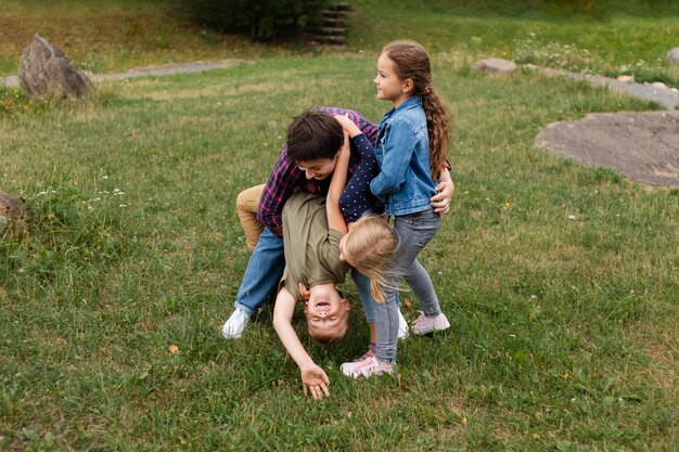 Donna e bambini a tutto campo che giocano