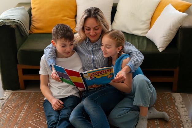 Full shot woman and kids reading comics indoors