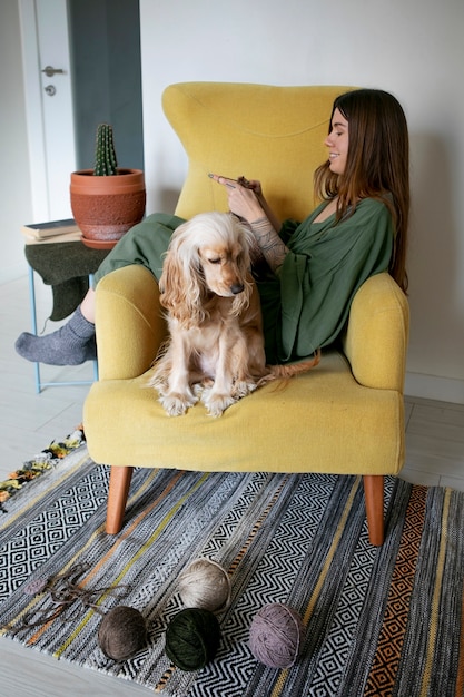 Full shot woman knitting with dog