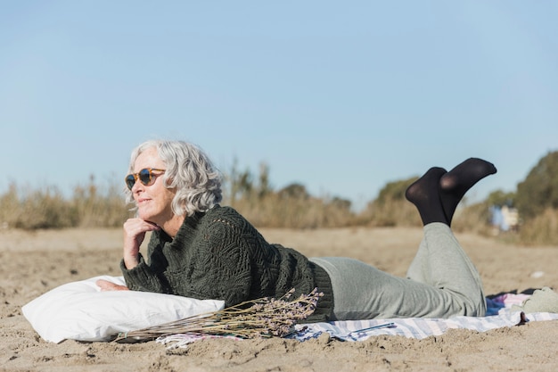 Full shot woman laying on the beach