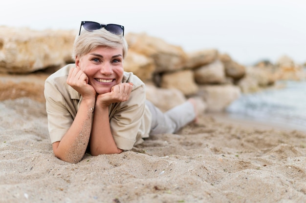 Donna della foto a figura intera che pone sulla spiaggia