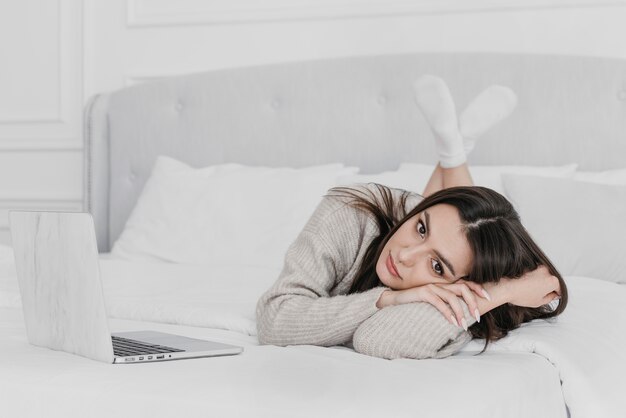 Full shot woman laying in bed