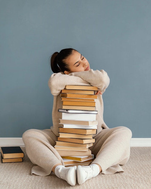 Полный снимок женщины, лежащей на стопке книг