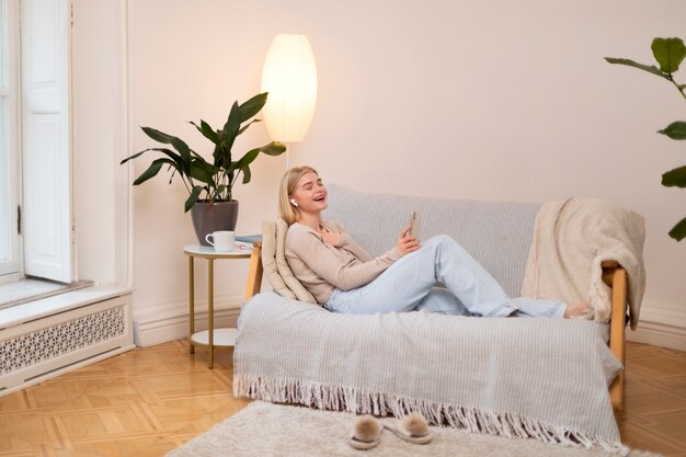 Full shot woman laying on couch