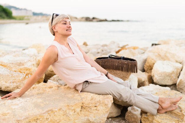 Full shot woman laying on rocks