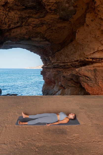 Foto gratuita donna a tutto campo posa su yoga mt