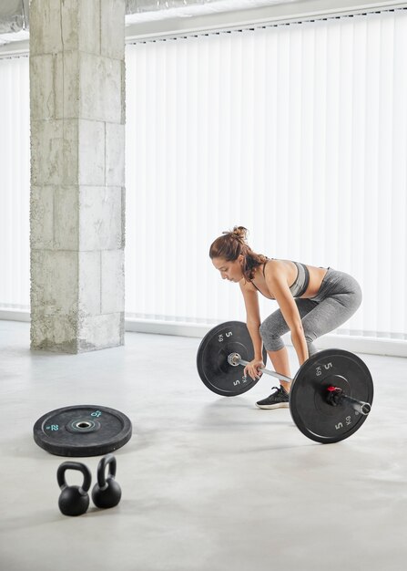 Full shot woman lifting weights