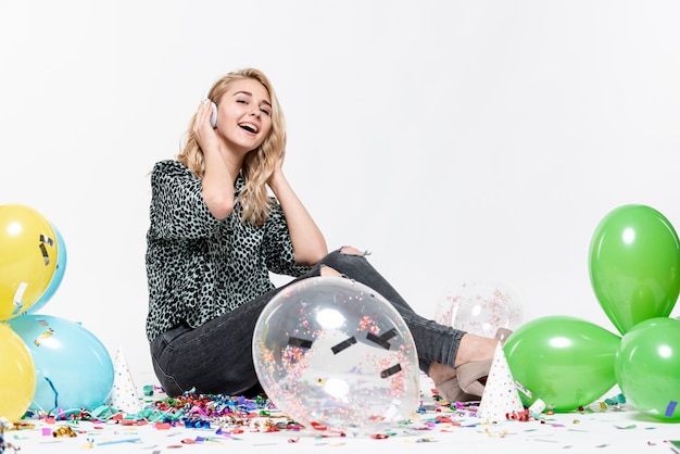 Full-shot woman listening to music surrounded by balloons