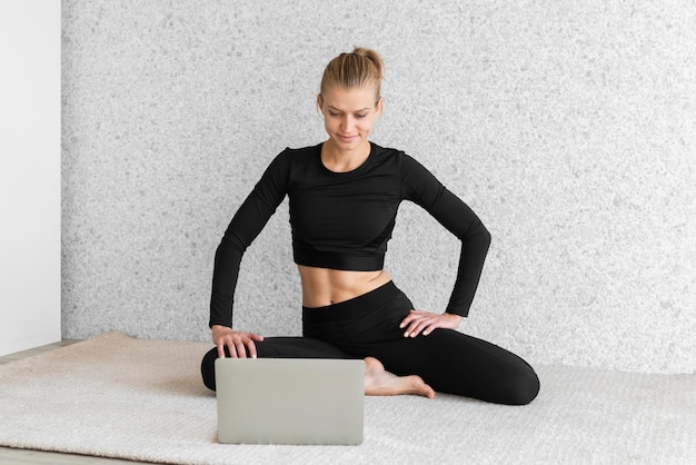 Full shot woman looking at laptop