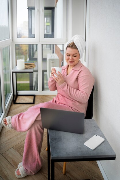 Full shot woman looking at laptop