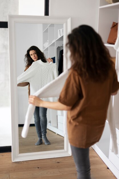 full shot woman looking in the mirror