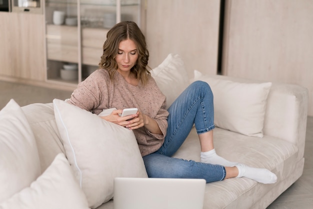 Full shot woman looking at smartphone