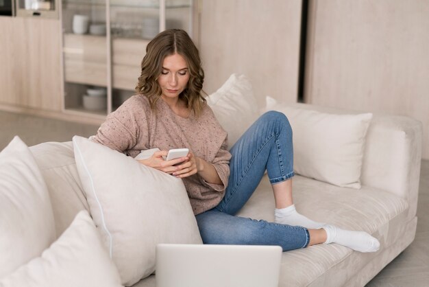 Full shot woman looking at smartphone