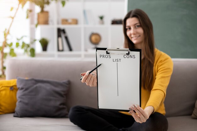 Full shot woman making list with clipboard