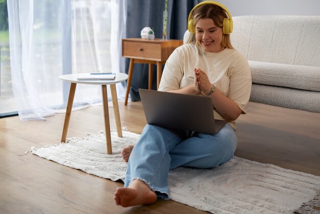 Donna a figura intera che effettua videochiamate con il laptop