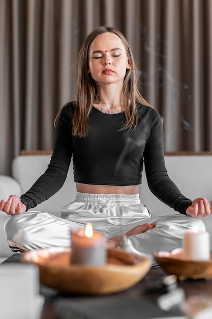 Full shot woman meditating on couch