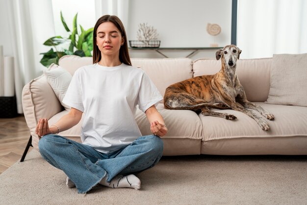 Full shot woman meditating at home