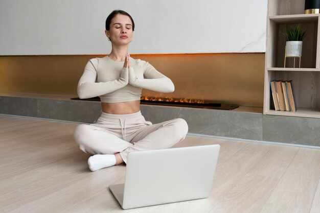 Full shot woman meditating indoors