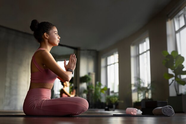 Full shot woman meditating indoors