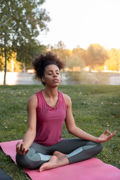 Full shot woman meditating on mat