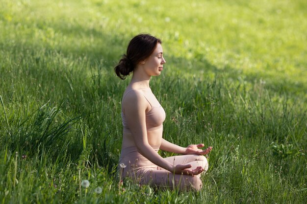 自然の中で瞑想するフルショットの女性