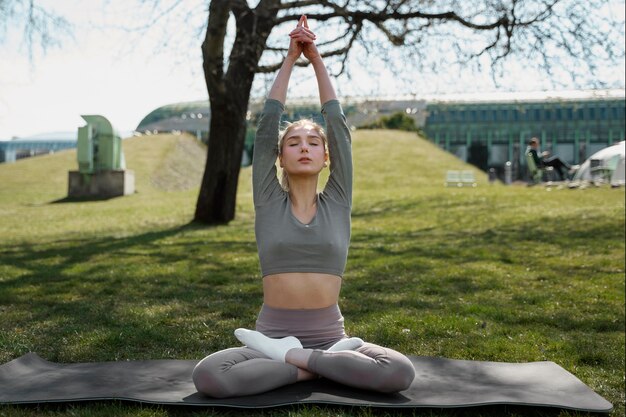 無料写真 マットの上で瞑想するフルショットの女性
