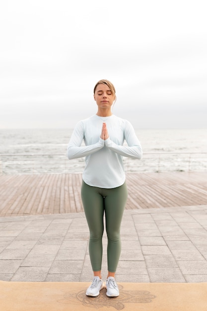 Full shot woman meditating outdoors