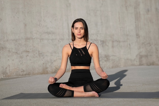 Full shot woman meditating outdoors