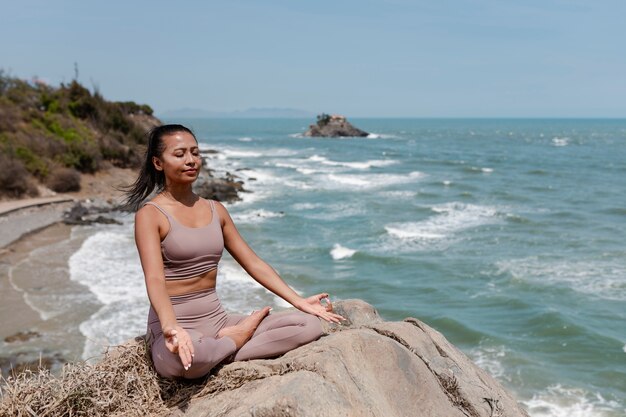 Full shot woman meditating outdoors