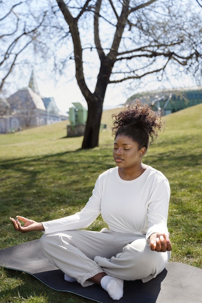 Full shot woman meditating outdoors