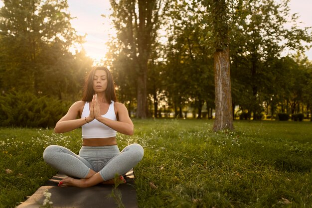 Full shot woman meditating outdoors