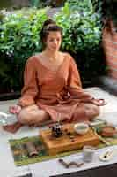 Free photo full shot woman meditating outdoors