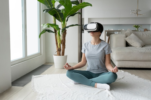 Free photo full shot woman meditating with vr glasses