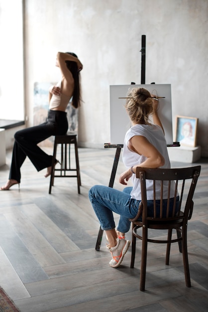 full shot woman painting on canvas