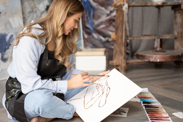 full shot woman painting on canvas