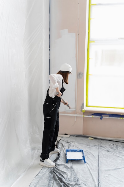 Full shot woman painting house wall
