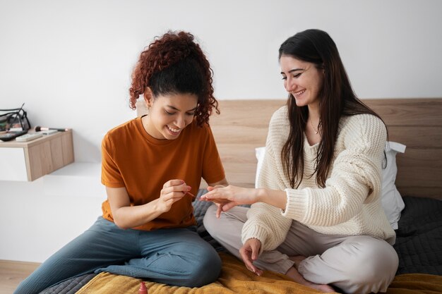 Full shot woman painting roommates nails