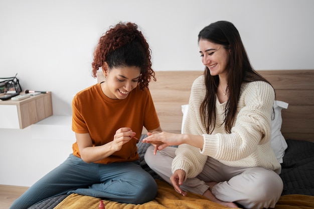 Full shot woman painting roommates nails