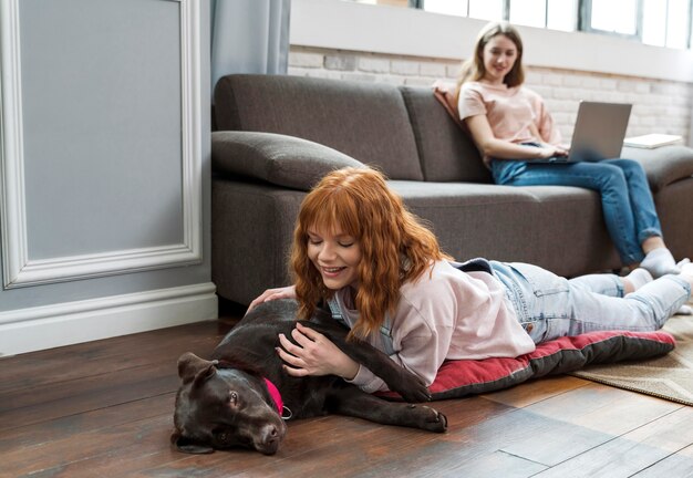 Full shot woman petting dog on floor