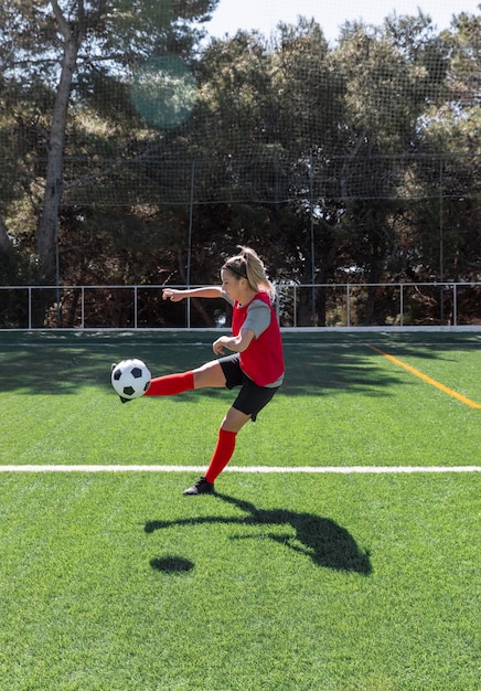 Foto gratuita donna piena del colpo che gioca a calcio