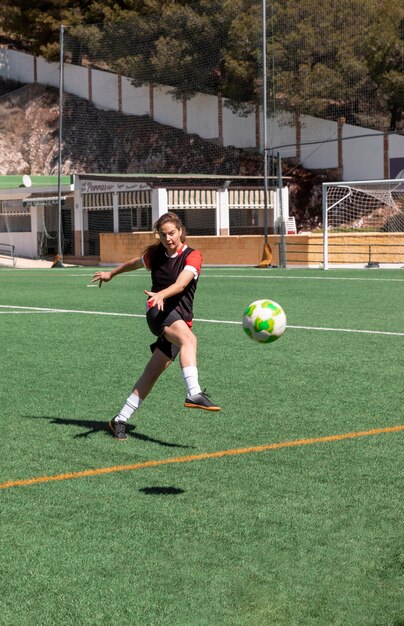 Full shot woman playing football