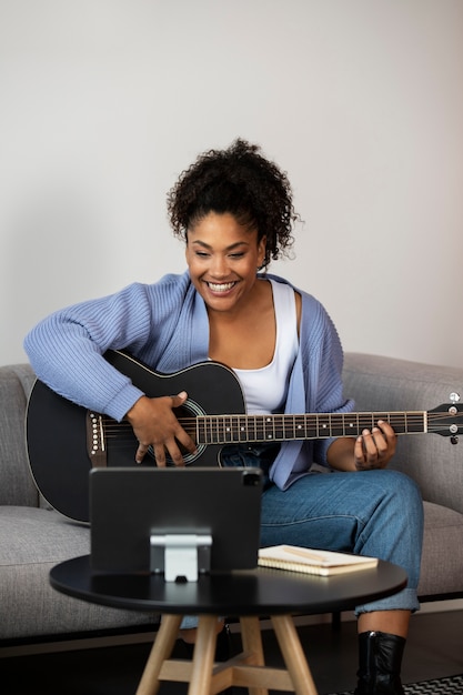 Free photo full shot woman playing the guitar