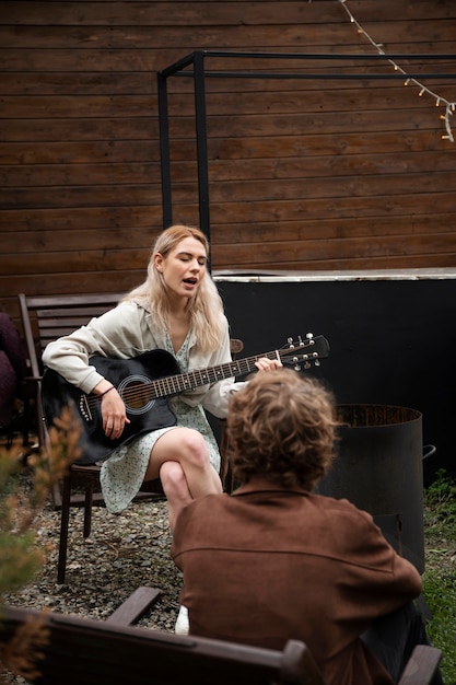 Free photo full shot woman playing the guitar