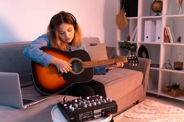 Full shot woman playing the guitar