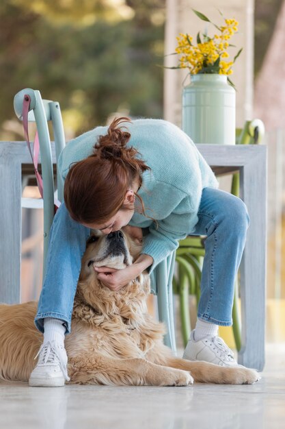 Полный снимок женщины, играющей с милой собакой