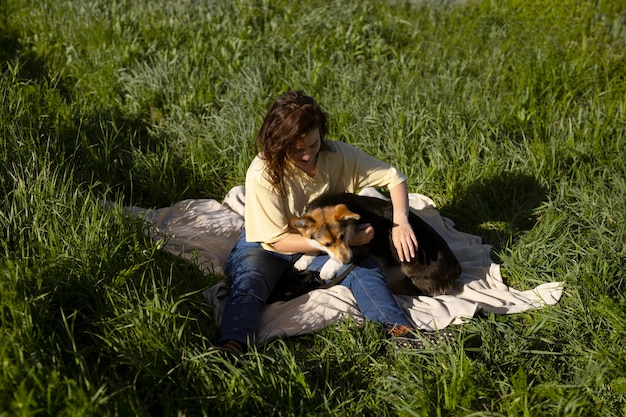 Full shot woman playing with dog