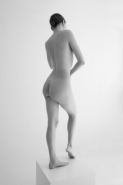 Full shot woman posing black and white nudity