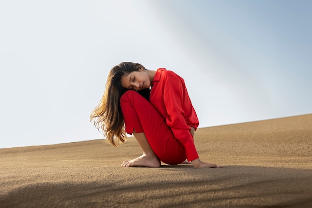 砂漠でポーズをとるフルショットの女性